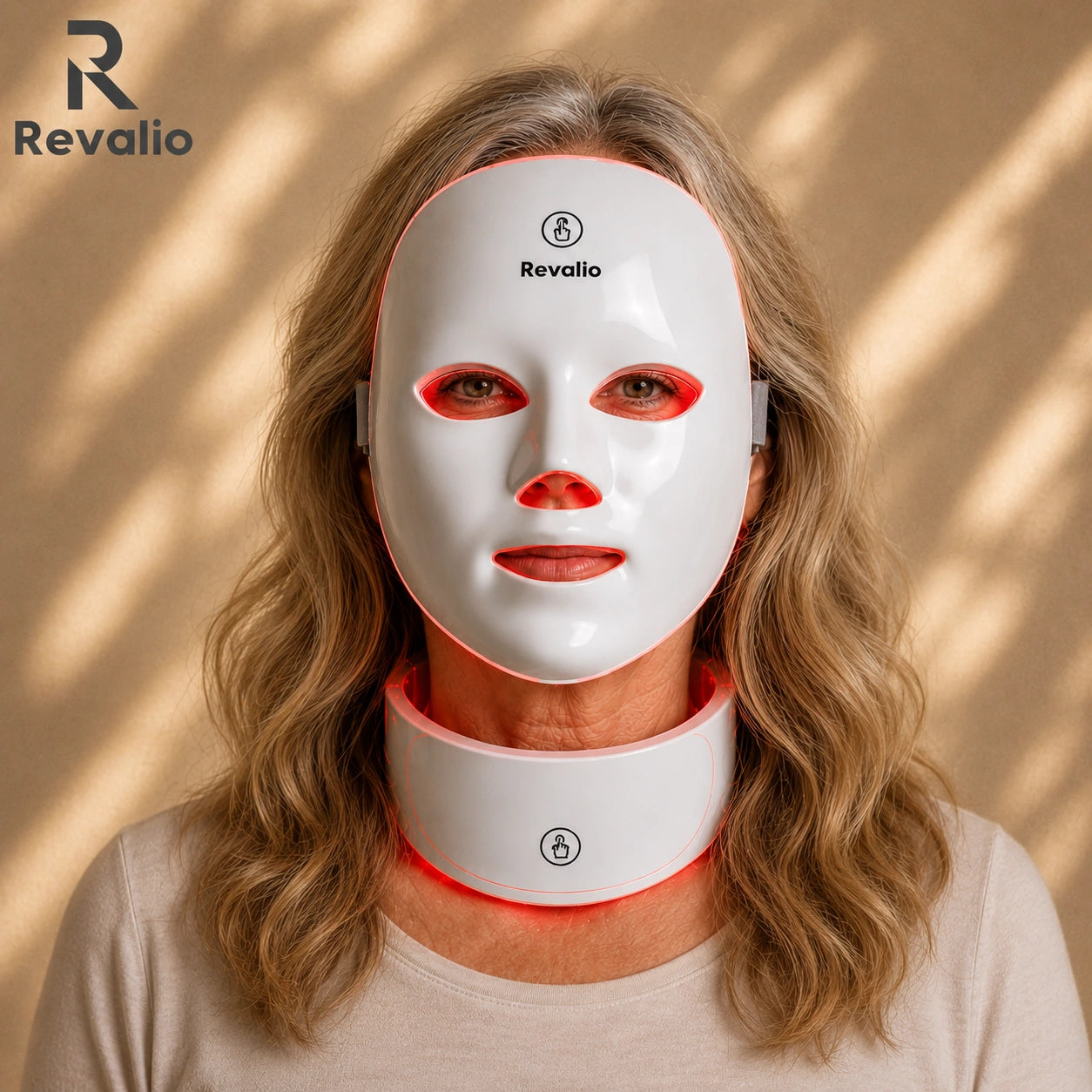 Woman wearing a Revalio LED face and neck mask on a beige background