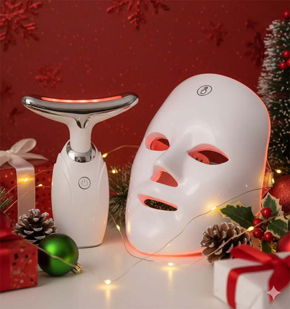 Revalio LED red light face mask and neck device displayed among Christmas gifts, pinecones and fairy lights, showcasing a festive skincare gift set for the 2025 holiday season.