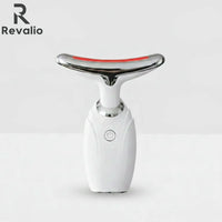 Front view of the white Revalio LED Facial Neck Massager standing upright against a white and grey background.