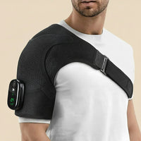 Man wearing the Revalio Heated Shoulder Massager Brace over a white T shirt showing adjustable strap and digital controller on his upper arm.