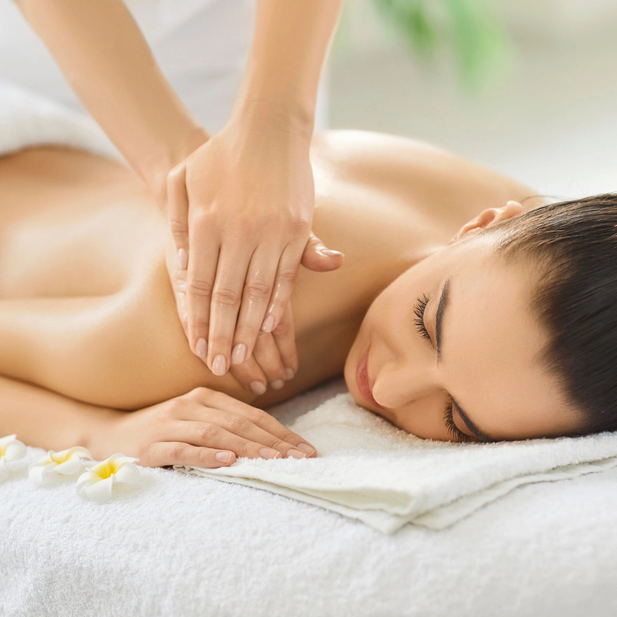 A woman relaxing during a gentle back massage, representing calmness, wellness and the inviting atmosphere of subscribing to the Revalio newsletter.